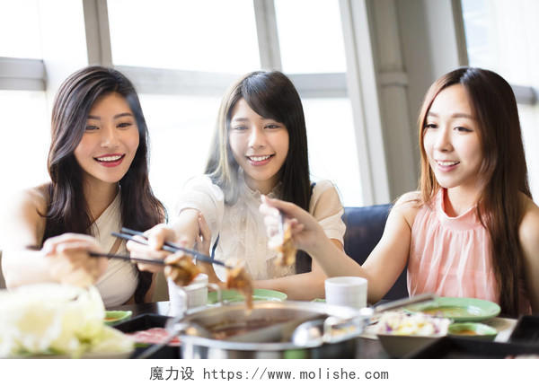 快乐的年轻妇女组吃火锅笑脸笑容